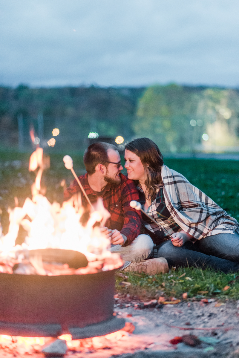 Fall engagement session by camp fire in Granite Hill Camping Resort