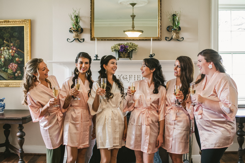 A beautiful stormy April wedding at Springfield Manor in Thurmont Maryland bridesmaids cheers with custom robes and champagne