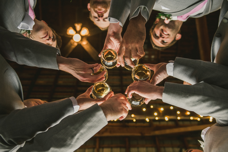 A beautiful stormy April wedding at Springfield Manor in Thurmont Maryland groomsmen cheersing in a barn