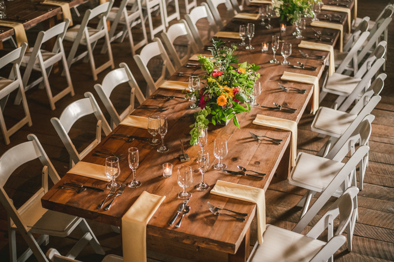 Gorgeous summer wedding reception details using farmhouse tables and Sungold Flower Co florals at Rocklands Farm Winery in Poolesville, Maryland by Britney Clause Photography a husband and wife wedding photographer team in Maryland