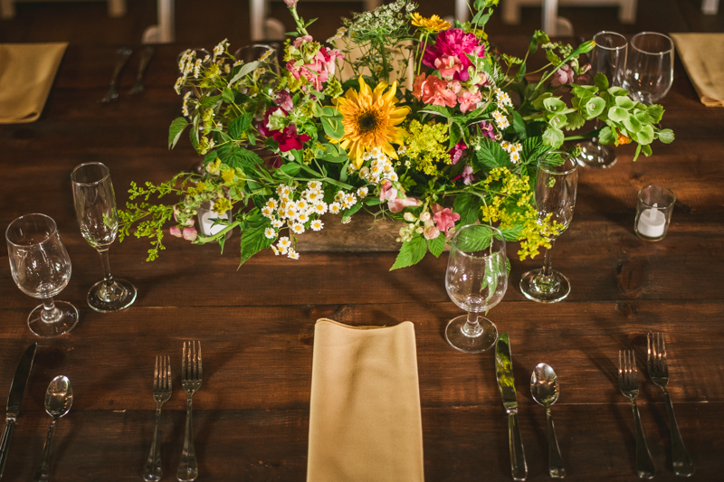Gorgeous summer wedding reception details using farmhouse tables and Sungold Flower Co florals at Rocklands Farm Winery in Poolesville, Maryland by Britney Clause Photography a husband and wife wedding photographer team in Maryland