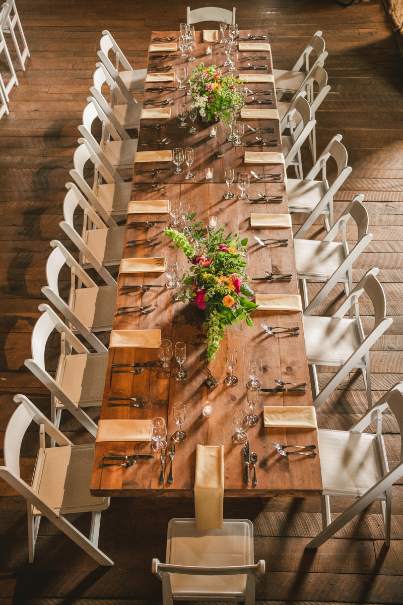 Gorgeous summer wedding reception details using farmhouse tables and Sungold Flower Co florals at Rocklands Farm Winery in Poolesville, Maryland by Britney Clause Photography a husband and wife wedding photographer team in Maryland