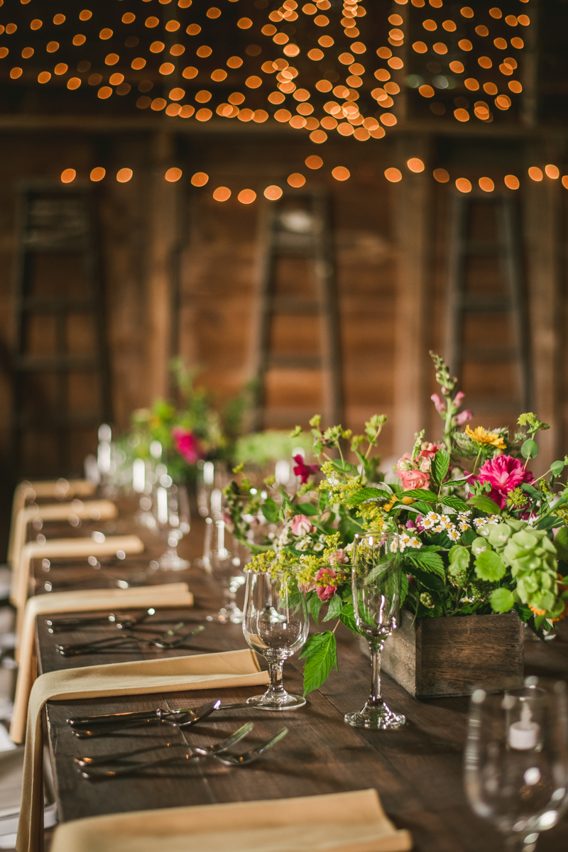 Gorgeous summer wedding reception details using farmhouse tables and Sungold Flower Co florals at Rocklands Farm Winery in Poolesville, Maryland by Britney Clause Photography a husband and wife wedding photographer team in Maryland