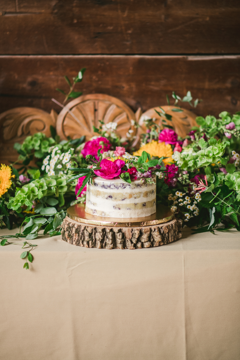 Gorgeous summer wedding reception details using farmhouse tables and Sungold Flower Co florals at Rocklands Farm Winery in Poolesville, Maryland by Britney Clause Photography a husband and wife wedding photographer team in Maryland