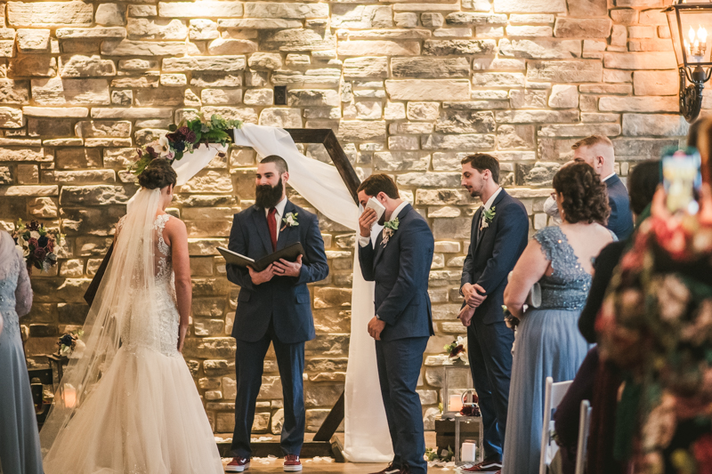 An emotional groom waiting for his bride at the end of the aisle at Kurtz's Beach in Pasadena, Maryland. Photo by Britney Clause Photography