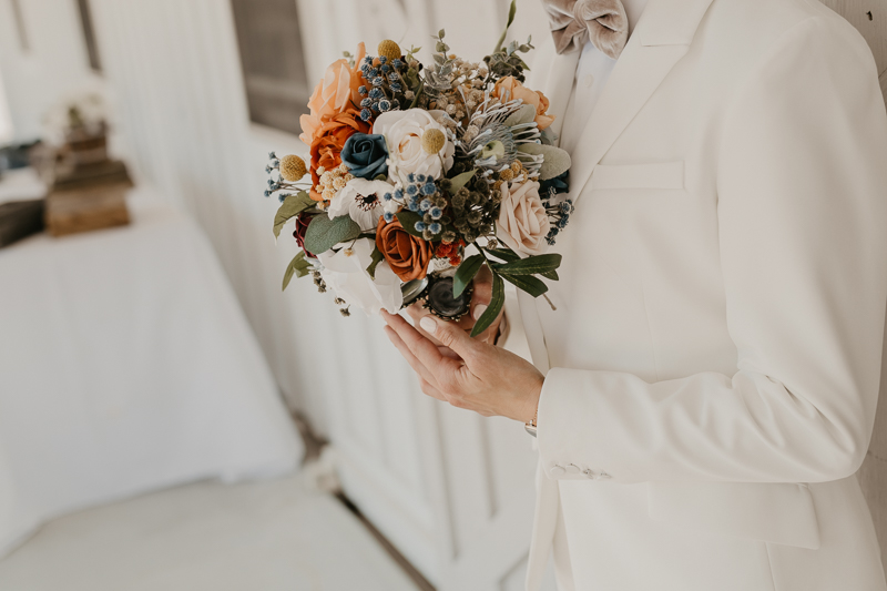 Two brides sharing a first touch at Kylan Barn in Delmar, Maryland by Britney Clause Photography